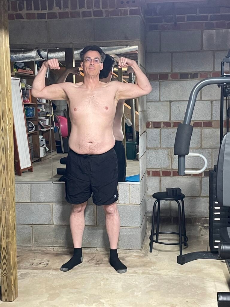 Gary Hardin Week 1 front flexed progress photo December 2025 - men over 50 arm and shoulder development